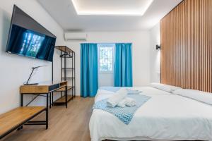 a bedroom with a bed with a television on the wall at El Nogal Home in Málaga