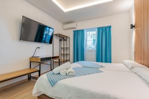 a bedroom with a large bed and a flat screen tv at El Nogal Home in Málaga