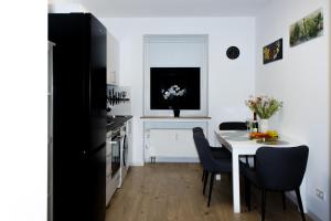 Una cocina y un comedor con una mesa y sillas blancas. en Cozy Apartment Wuppertal, en Wuppertal