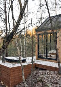 a house in the woods with a wooden deck at Forestic Lietuva in Vilionys