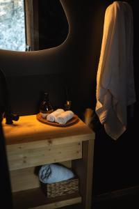 a bathroom with a table with towels and a mirror at Forestic Lietuva in Vilionys