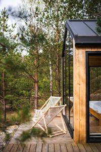 a bench on a deck next to a cabin at Forestic Lietuva in Vilionys
