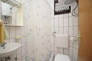 un baño con inodoro y lavabo en Apartments Karamarko, en Baška 38 fotos más
