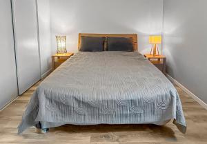 a large bed in a room with two lamps at Maison lumineuse, terrasse, à 10 min des plages in Saint-Père-en-Retz