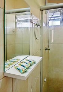 a bathroom with a shower and a sink with towels at Espaço inteiro no Centro Histórico, bem localizado in Porto Alegre