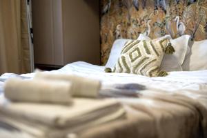 un letto con lenzuola e cuscini bianchi in una camera da letto di Cozy Studio Retreat - Quiet, Premium Stay a Timişoara Altre 17 foto