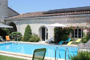 a swimming pool in front of a house with chairs at Les charmes de Vincent - le loft Cabernet in Fronsac +5 photos