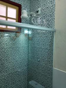 a bathroom with a shower with a glass door at Pousada Santa Bárbara in Tiradentes