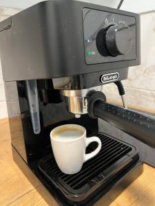 a cup of coffee is being brewed in a coffee machine at Apart Canada Center in Baia Mare