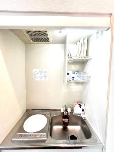 a small kitchen with a sink and a mirror at Ueno-Tokyo Garden in Tokyo
