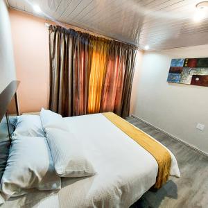 a bedroom with a white bed with a window at Cozy Livin - Duplex in Maseru
