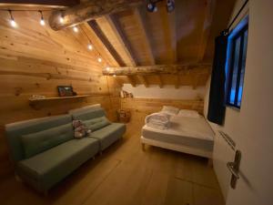un soggiorno con un divano e un letto di Chalet au cœur de la montagne a Valmeinier