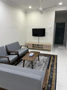 a living room with a couch and chairs and a flat screen tv at Lanuna Homestay Banting in Banting
