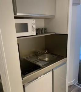 a small kitchen with a sink and a microwave at studio centre-ville historique in Chambéry