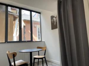a room with a table and two chairs and a window at studio centre-ville historique in Chambéry