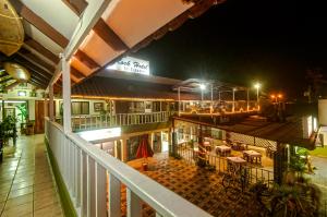 a balcony view of a restaurant at night at Cadillac Rock Beach Hotel in Jacó
