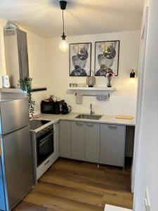 a kitchen with a sink and a refrigerator at ELLY Arena Zagreb Apartment in Zagreb +18 photos