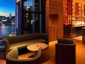 un bar con divano e tavolo in un edificio di AKI Hong Kong - MGallery a Hong Kong