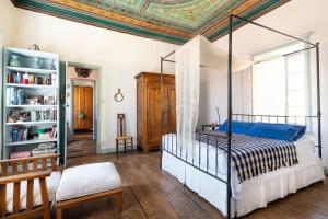 a bedroom with a canopy bed and a book shelf at Villa Melograno HALKI in Halki