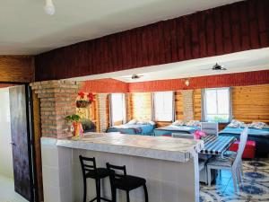 a room with a bar with chairs and beds at Cabañas El Encuentro in Parras de la Fuente