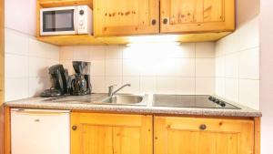 eine Küche mit Spüle und Mikrowelle in der Unterkunft Les fermes de Saint Sorlin H 105 - 2P6 in Saint-Sorlin-dʼArves + 9 Fotos