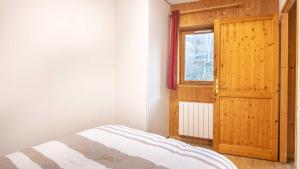 ein Schlafzimmer mit einem Bett und einem offenen Fenster in der Unterkunft Les fermes de Saint Sorlin H 105 - 2P6 in Saint-Sorlin-dʼArves