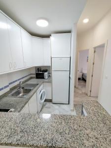 a small kitchen with a sink and a refrigerator at Ipanema Costa - Islantilla in Islantilla