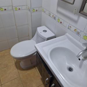 ダル・エス・サラームにあるSwahili Rose Bay H & appartmentの白いトイレと洗面台のあるバスルーム +18枚の写真