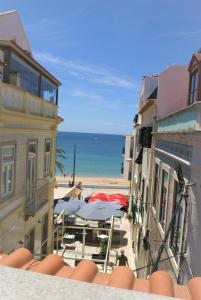 a view of the beach from a balcony with umbrellas at Plage,15 m, mer, Casa Melissa by SesimbraSunSea in Sesimbra