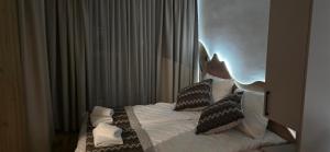 a bedroom with a bed with pillows on it at Apartman A2-3 u Apart hotel Vučko in Jahorina