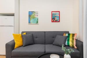a living room with a gray couch with colorful pillows at boat house - near Papafi metro station in Thessaloniki