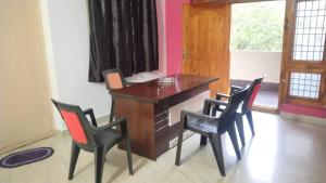 an office with a desk with chairs and a laptop at Rest N' Refresh Homes in Visakhapatnam