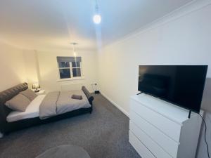 a living room with a couch and a flat screen tv at Comfortable Double Rooms in a Beautiful House in Ipswich