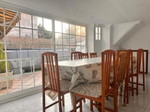 a dining room with a table and chairs and windows at Casa Independiente en Quintela - HomeyGalicia in Vigo