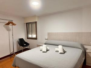 a bedroom with a bed with towels on it at Casa Independiente en Quintela - HomeyGalicia in Vigo +14 photos