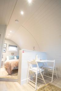 a bedroom with a bed and a table and a desk at Hood Lane Farm - The Pod - Luxury Glamping Holiday Lodge in Arley