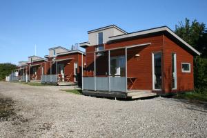 une rangée de maisons modulaires sur une route en gravier dans l'établissement Sorø Camping & Cottages, à Sorø