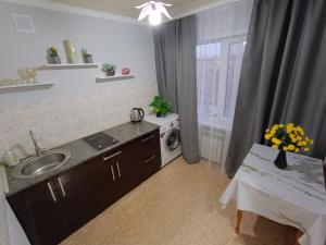 a kitchen with a sink and a washing machine at Современные апартаменты в центре города in Ustʼ-Kamenogorsk