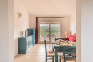 a kitchen and dining room with a table and chairs at Baia Bianca Apartments Sardinia in Baja Sardinia
