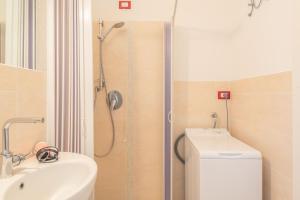 a bathroom with a shower and a toilet and a sink at Baia Bianca Apartments Sardinia in Baja Sardinia +36 photos
