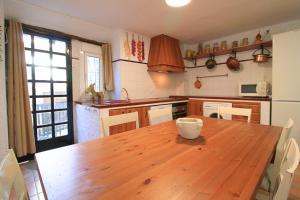 eine Küche mit Holztisch und Holzboden in der Unterkunft La Casa de la Tierra by SIERRA VIVA in Los Marines