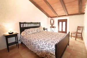 ein Schlafzimmer mit einem Bett und einem Tisch und Stühlen in der Unterkunft La Casa de la Tierra by SIERRA VIVA in Los Marines