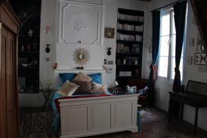 a living room with a couch with pillows on it at Le Boudoir d'artiste in Semur-en-Auxois