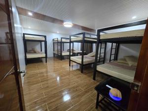 three bunk beds in a room with a wooden floor at Villa Luminous Private Resort in Upi