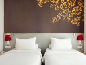 A bed or beds in a room at Ibis Styles Malang