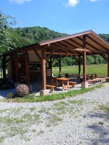 a wooden pavilion with picnic tables in a field at Domek Wilcza Wola 2 in Górzanka