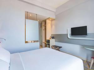 A bed or beds in a room at Ibis Styles Malang