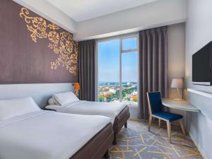 A bed or beds in a room at Ibis Styles Malang