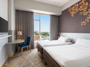 A bed or beds in a room at Ibis Styles Malang