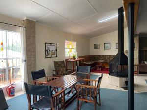 un salon avec une table et des chaises et une cheminée dans l'établissement Mvemve Lodge at GrootPoort, à Memel